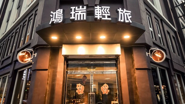 A modern building with a dark facade and illuminated entrance. - Home Rest Hotel (Taitung)