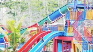 Ein Wasserpark mit mehreren Rutschen und einer Kletterattraktion.