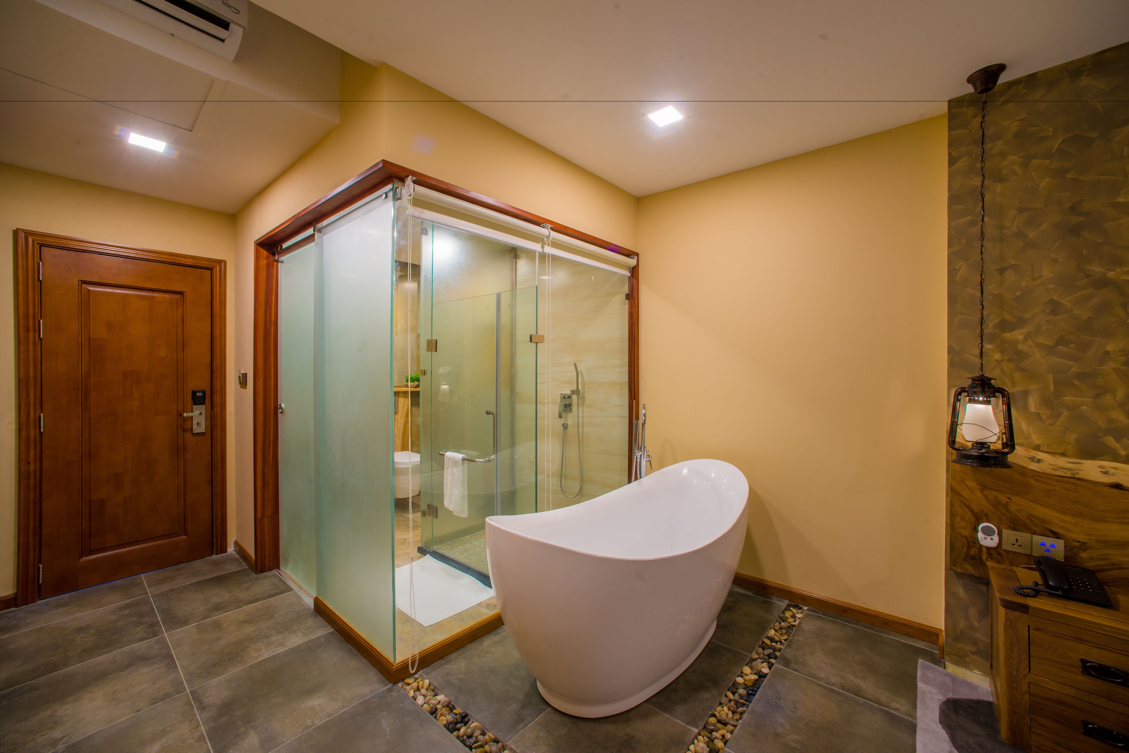 A modern bathroom with a freestanding bathtub, a glass-enclosed shower, and a wooden vanity.