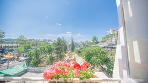 Un balcón con vista a un paisaje urbano, incluyendo edificios y árboles.