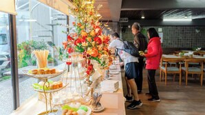 Montaje de bufé con diferentes opciones de comida y una decoración floral.