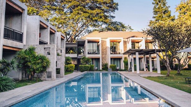 A modern hotel with a central pool, multiple balconies, and lush greenery. - B2 Pai Premier Resort (Pai)