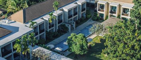 Un bâtiment moderne à plusieurs étages, doté d’espaces de détente en plein air et d’une piscine.