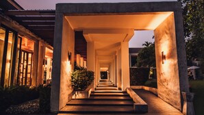 A modern building with a long, illuminated corridor leading to a covered entrance. - B2 Pai Premier Resort (Pai)