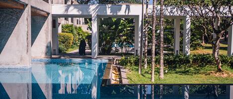 A swimming pool with a clear view of the surrounding architecture and greenery.