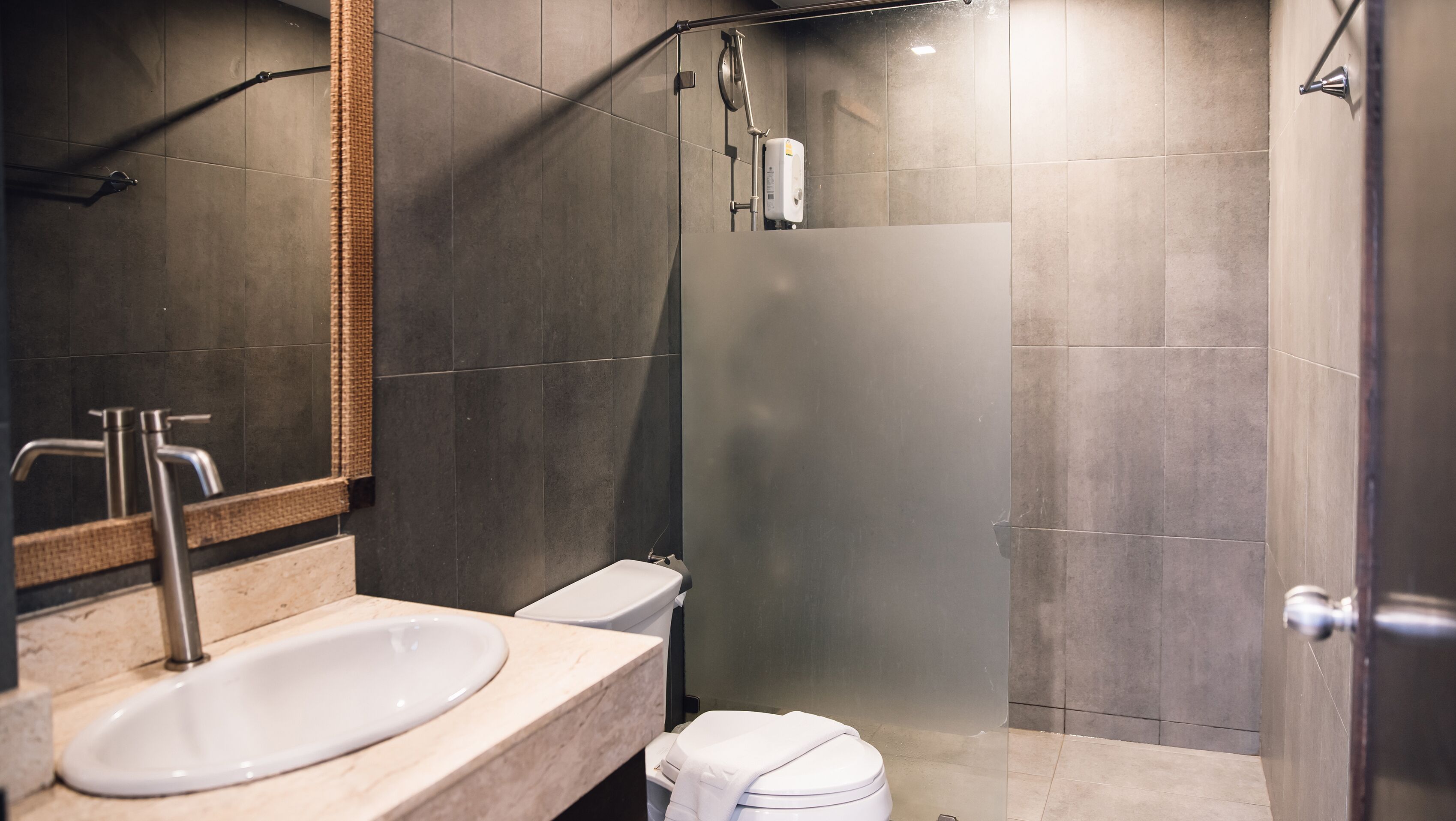 Un baño moderno con lavamanos grande, inodoro y cabina de ducha de vidrio.