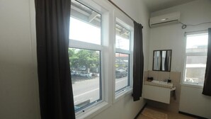 A small, clean room with a window, a sink, and a mirror. - Talofa Inn (Apia)