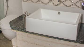 A bathroom with a white sink, a mirror, and a shower.