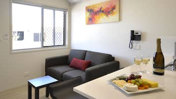 Deluxe appartement, 1 slaapkamer | Woonruimte | Een 50-inch flatscreentelevisie met digitale zenders en televisie