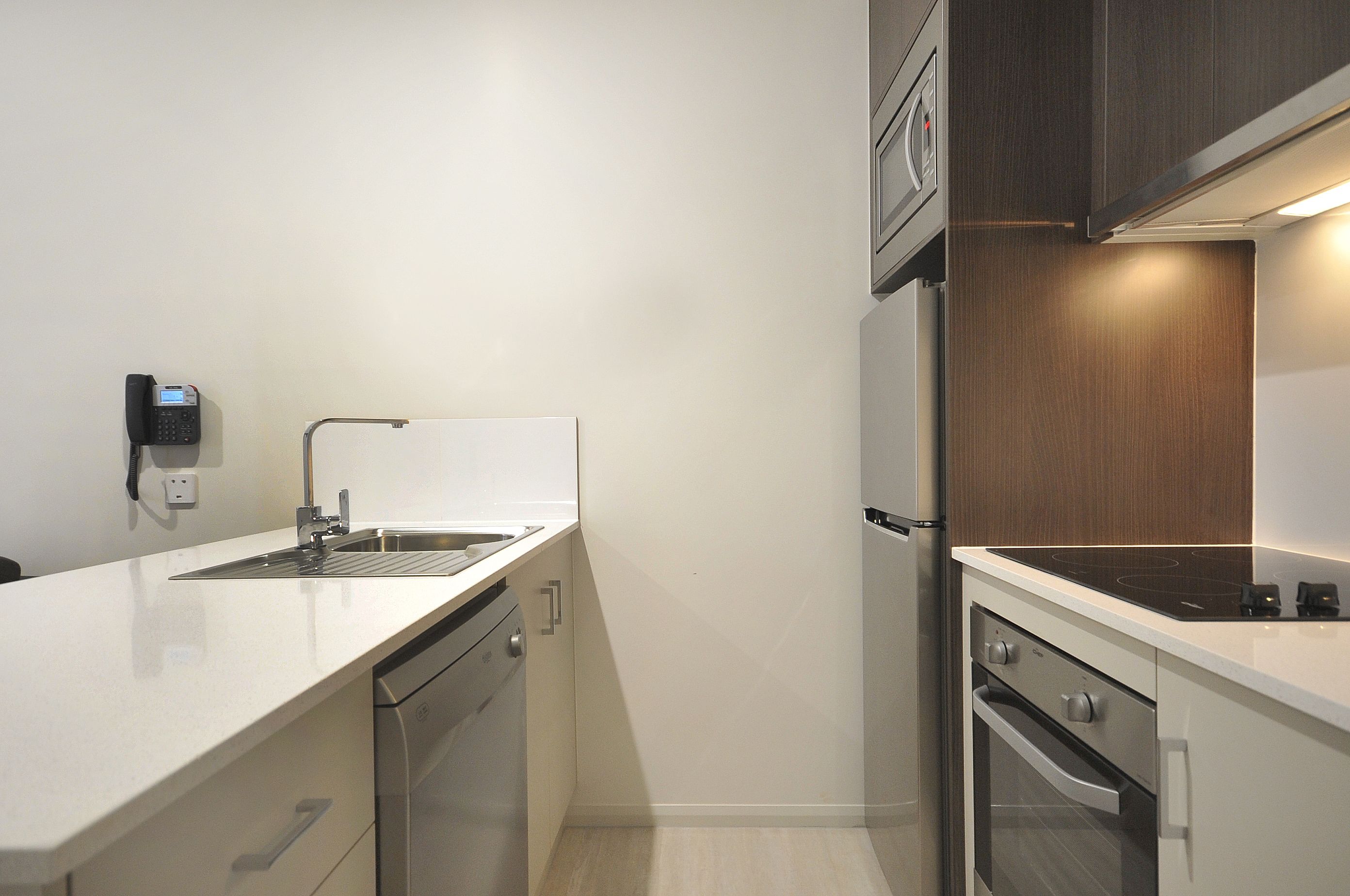 A compact kitchen with a dishwasher, oven, and a built-in stove.