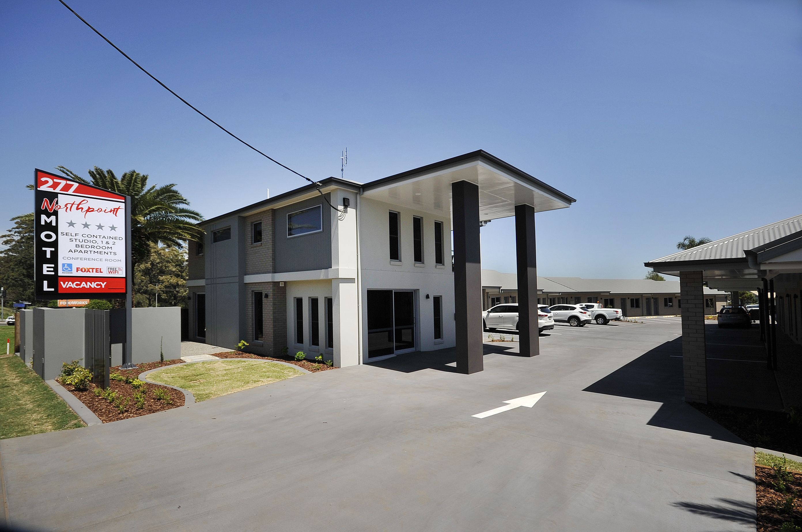 Un motel moderne, reconnaissable à son panneau indiquant l’adresse 277 Northpoint, proposant des chambres indépendantes, une chambre à coucher et une salle de conférence.