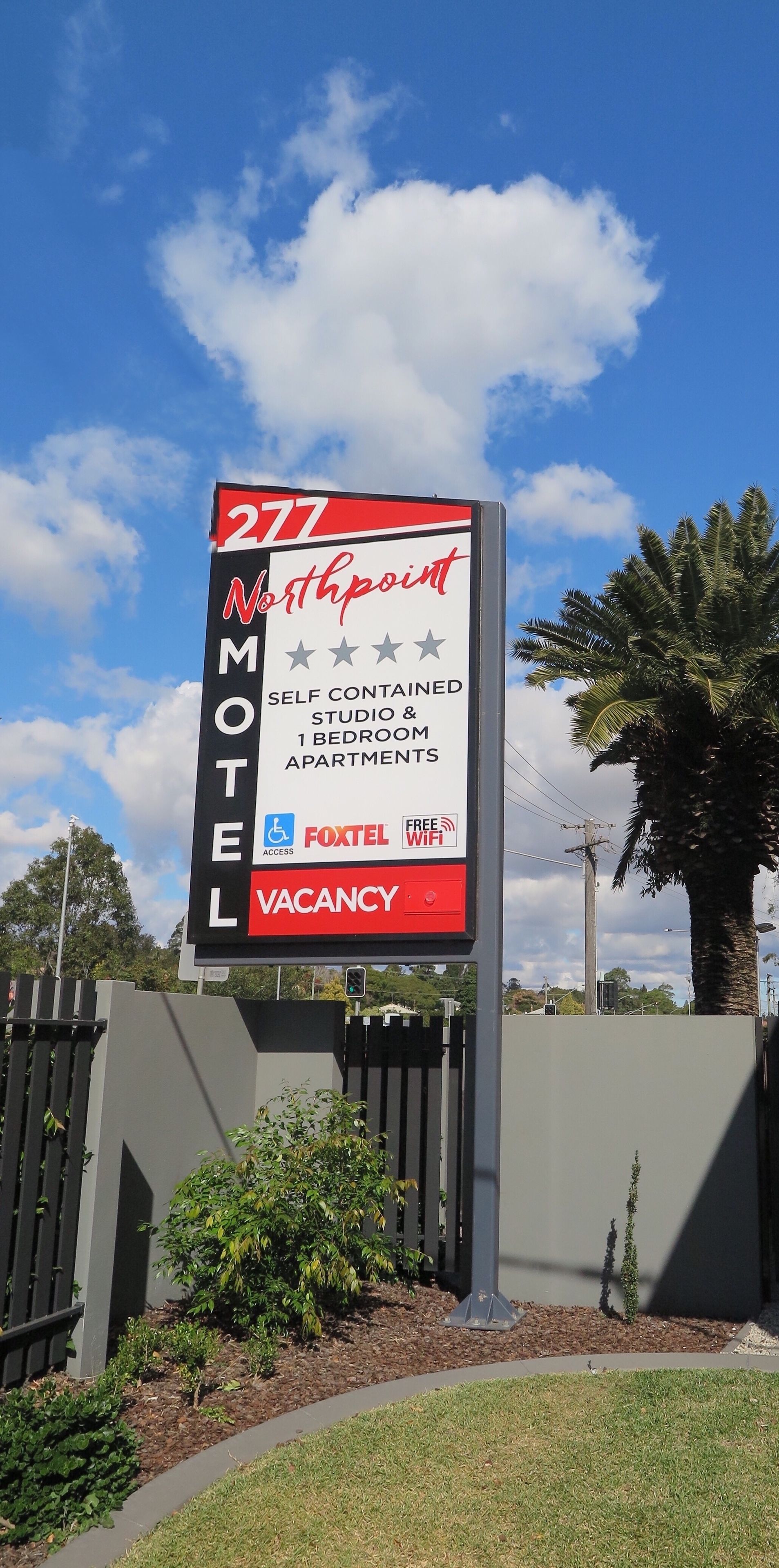 A motel sign with a vacancy notice, indicating self-contained studio and 1-bedroom apartments, accessibility, and free WiFi.