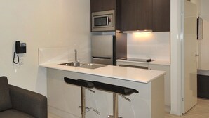 A modern kitchen with a white countertop, stainless steel appliances, and a built-in microwave. - Northpoint Motel (Harlaxton)