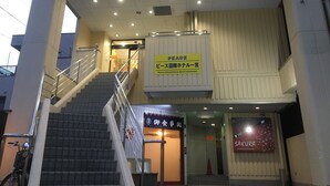 A hotel entrance with a staircase, a sign for the Peace International Hotel, and a Sakura Japanese Restaurant. - Peace International hotel Ichinomiya (Ichinomiya)