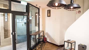 A modern interior with a glass door leading to a balcony, a wooden bench, and a small table with a book.