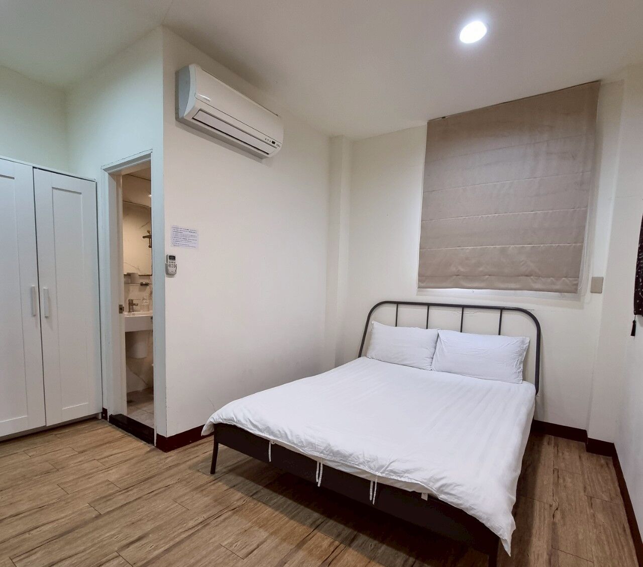 Une chambre à coucher comprenant un lit, une armoire et un appareil de climatisation.