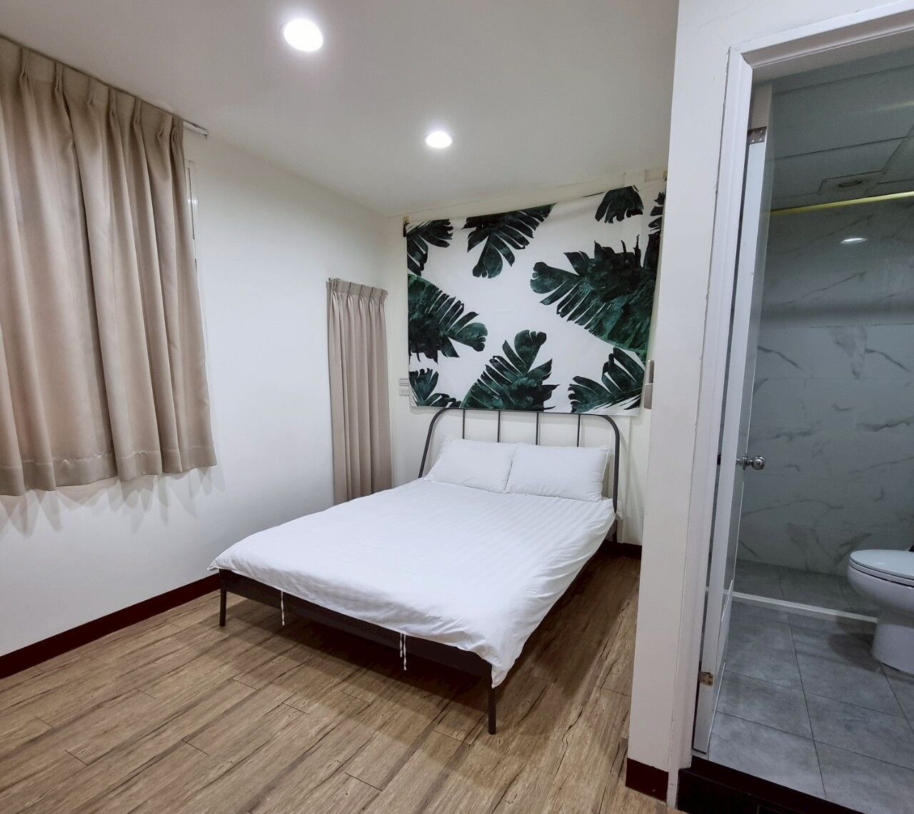 Una camera da letto con un letto, un angolo doccia e un bagno.