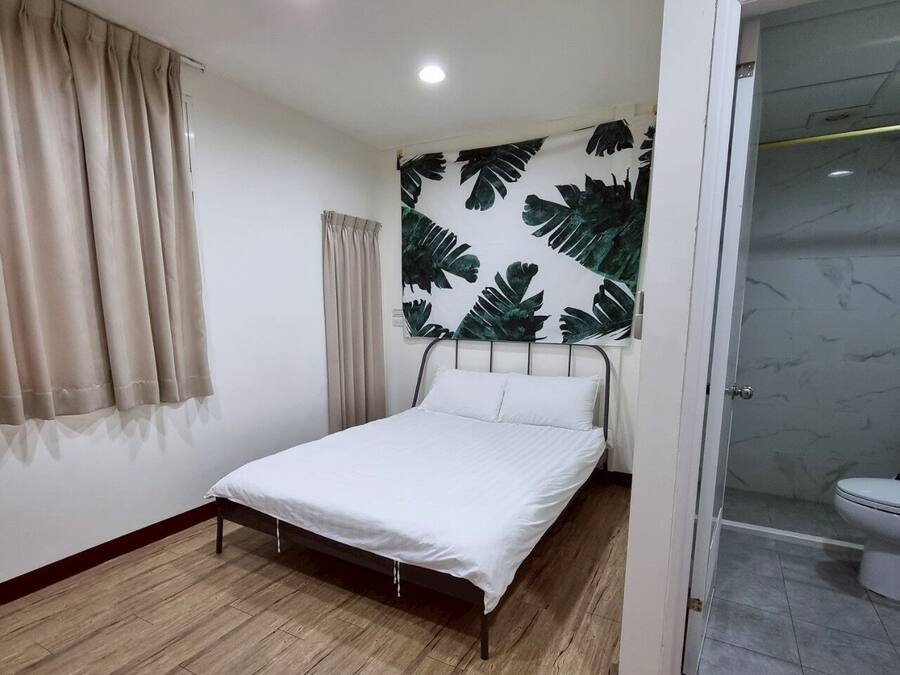 Una camera da letto con un letto, un angolo doccia e un bagno.