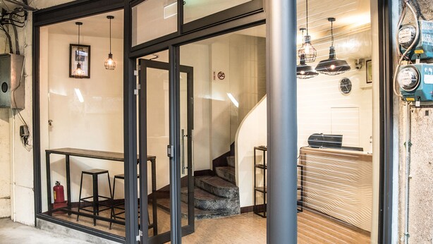 Ein modernes Interieur mit Glastür, einer Treppe und einem Barbereich.