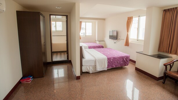A hotel room with a bed, a desk, a chair, a TV, and a wardrobe. - Chantai Hotel (Hualien City)