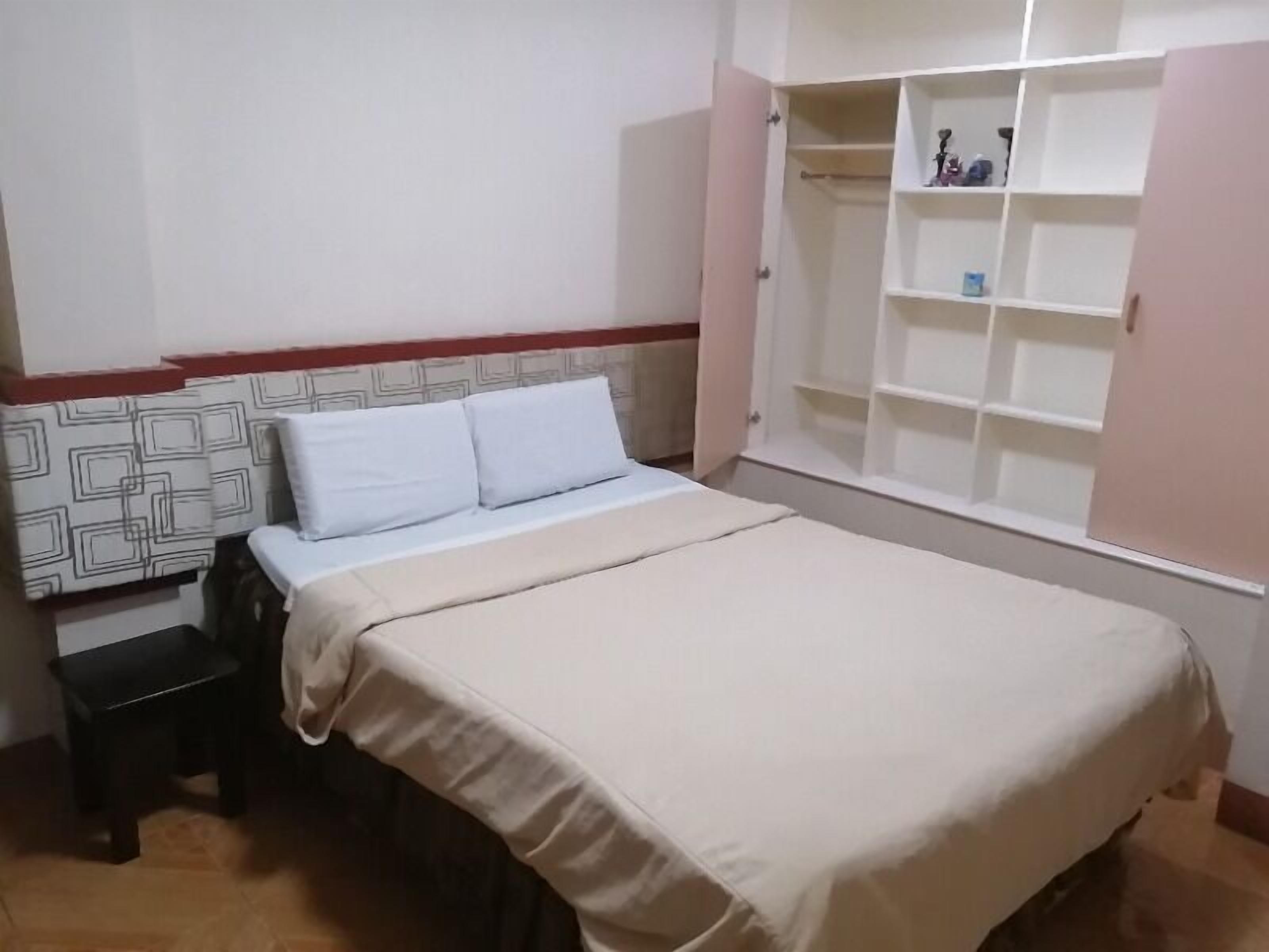 A bedroom with a bed, a nightstand, and a wardrobe.