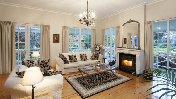A living room with a fireplace, a sofa set, a coffee table, and a chandelier. - Moulton Park Homestead (Sassafras)