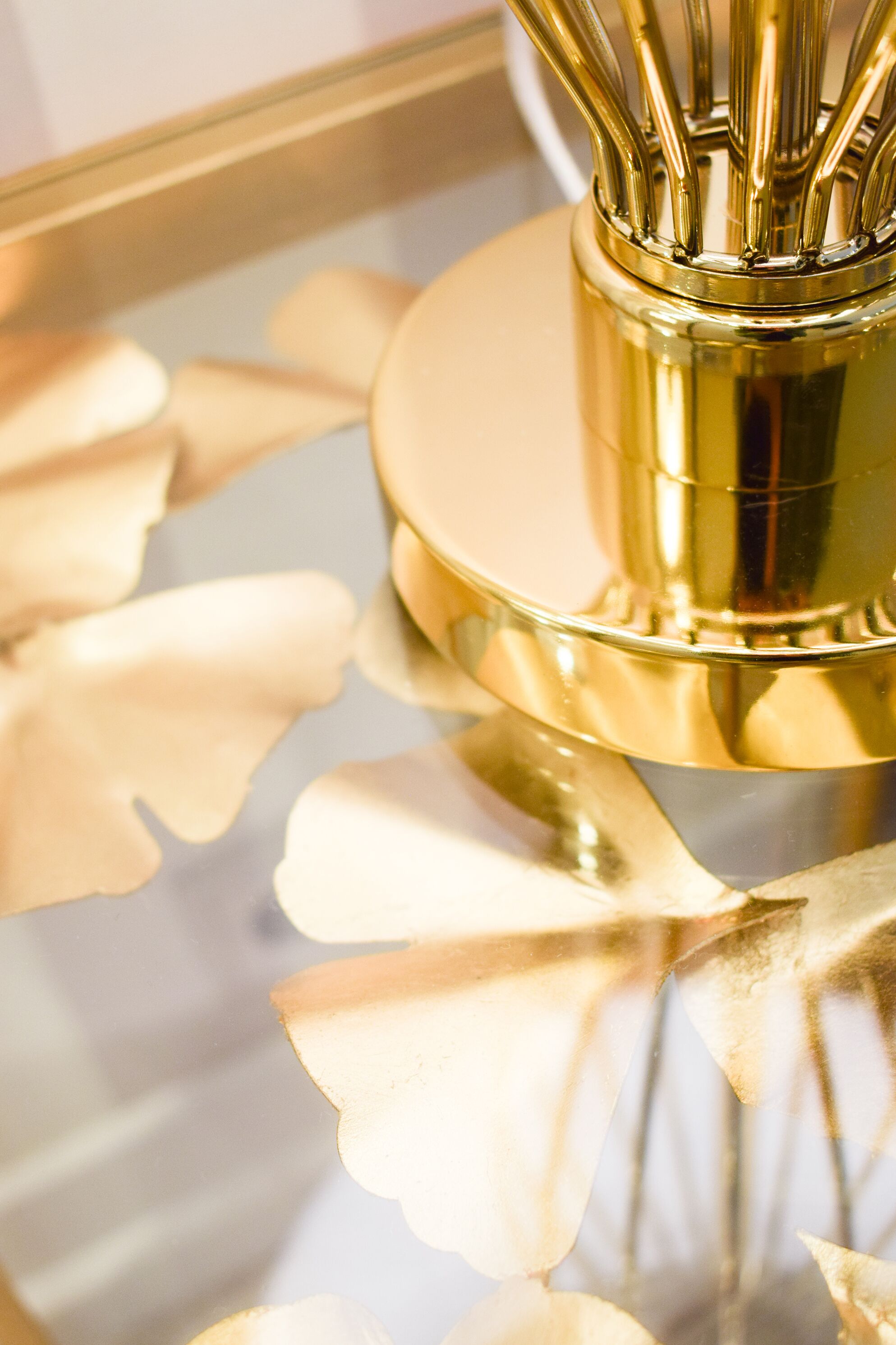Eine Nahaufnahme eines goldenfarbenen Objekts mit reflektierender Oberfläche, möglicherweise ein dekorativer Gegenstand oder ein Teil eines Möbelstücks.