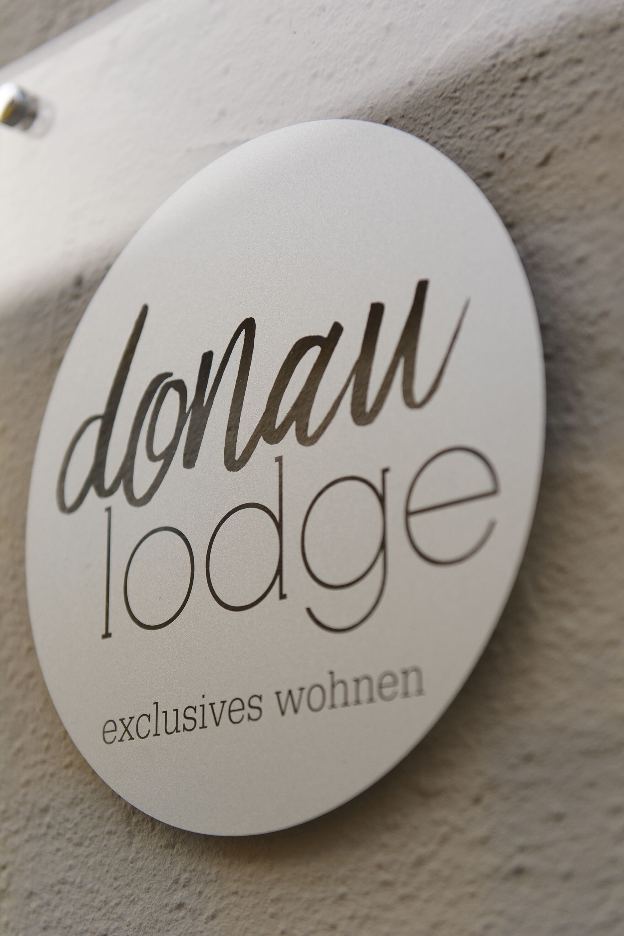 A circular sign with the text "donaw lodge" and "exclusives wohnen" indicating a lodging facility.