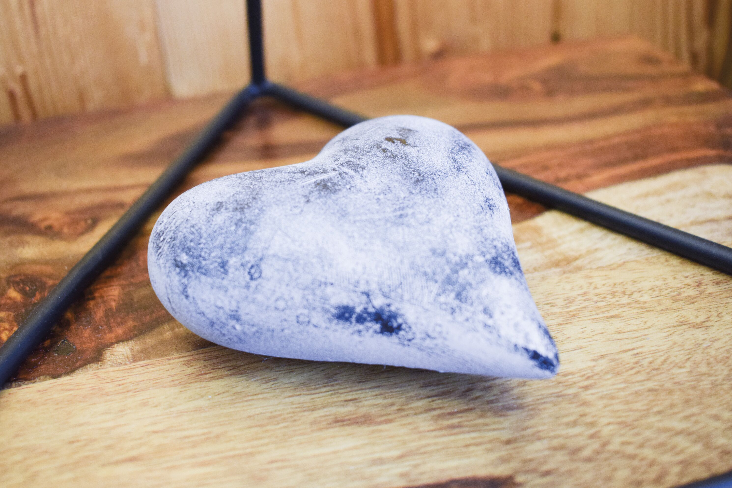 A heart-shaped object on a wooden surface.