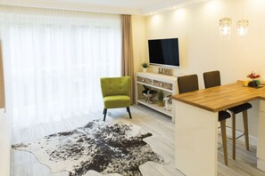 Leilighet, terrasse | Oppholdsområde | En 55-tommers Flatskjerm-TV med kabel-kanaler samt TV