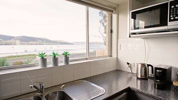 Waterfront Holiday Home - Esplanade 54 | Private kitchen | Fridge, microwave, oven, stovetop