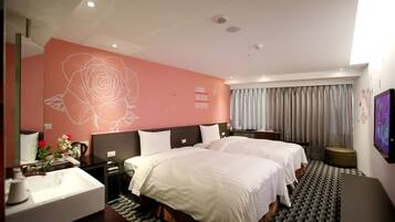 Quarto de hotel com duas camas, um mural grande na parede, banheiro com pia e televisão na parede.