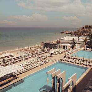 A resort with a large pool, sun loungers, and beach umbrellas. - Ocean Blue Resort (Mastita)