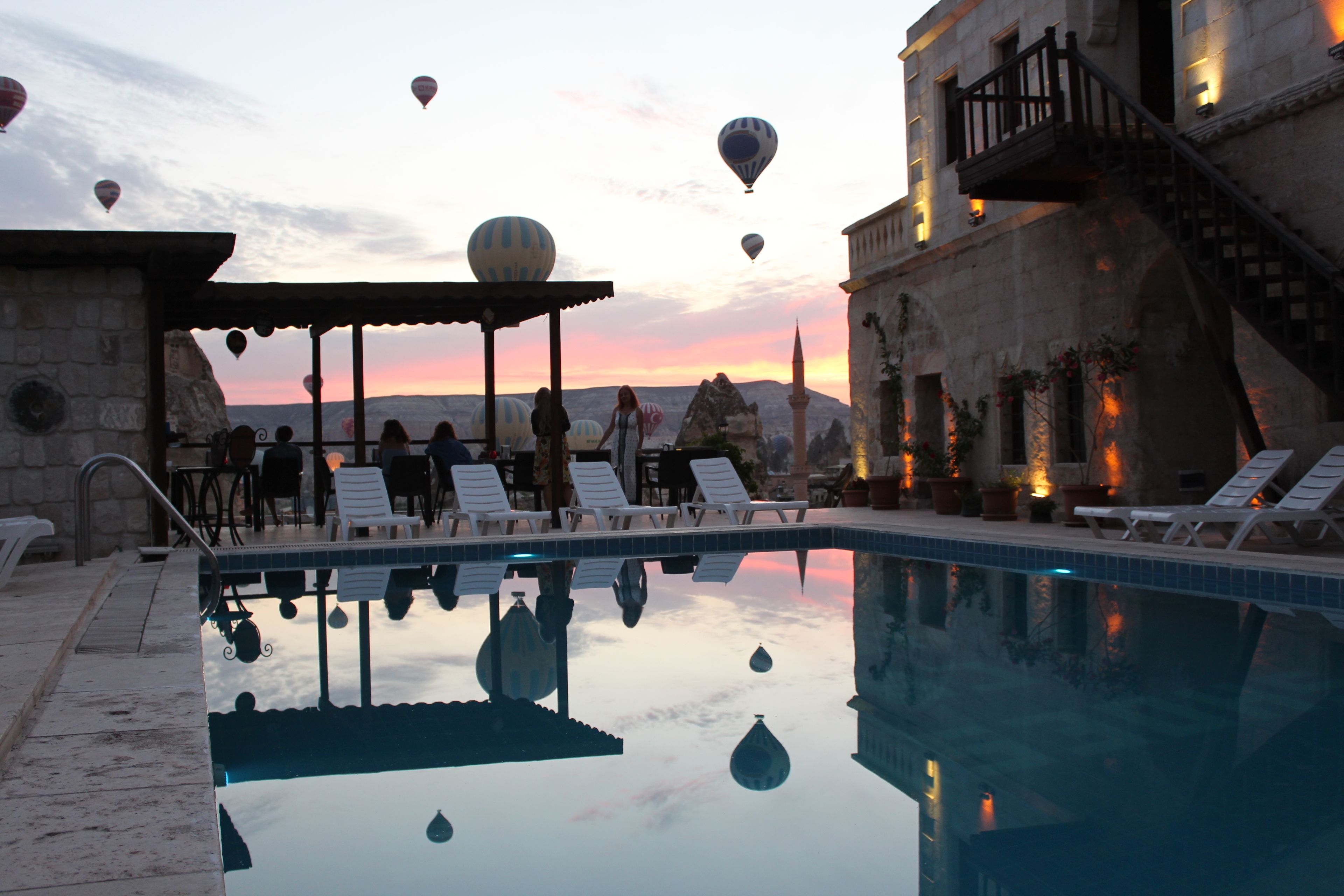 Una piscina al aire libre, sombrillas, tumbonas