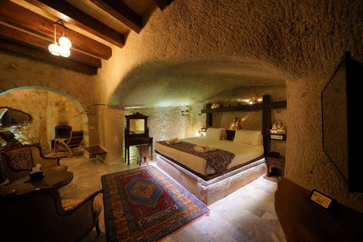A cozy room with a bed, a chair, a small table, and a rug.