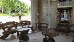 A wooden interior with a table and chairs, a sign for Bohol Divers Resort, and a view of the outside. - Bohol Divers Resort (Tagbilaran)
