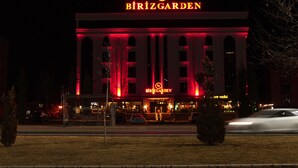 Un edificio con un letrero llamativo que dice "BIRZGARDEN" de noche.