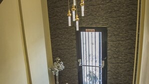 Una escalera moderna con puerta de cristal y una lámpara colgante.
