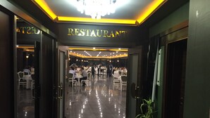 Un restaurante con suelo de mármol pulido, mesas y sillas blancas.