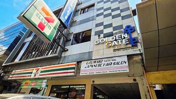 Een meerhoog gebouw met een 7-Eleven buurtwinkel op de begane grond, een Japans kapsalon en een Golden Gate Motor Inn.