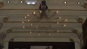 Der Eingang des Hotel Santa Cruz mit einem prächtigen Kronleuchter, einer Treppe und Topfpflanzen.