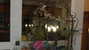 Ein großer Kupfertopf mit Blumen und einem dekorativen Spiegel.