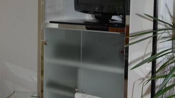 A modern kitchen with a built-in microwave, a glass cabinet, and a white radiator.