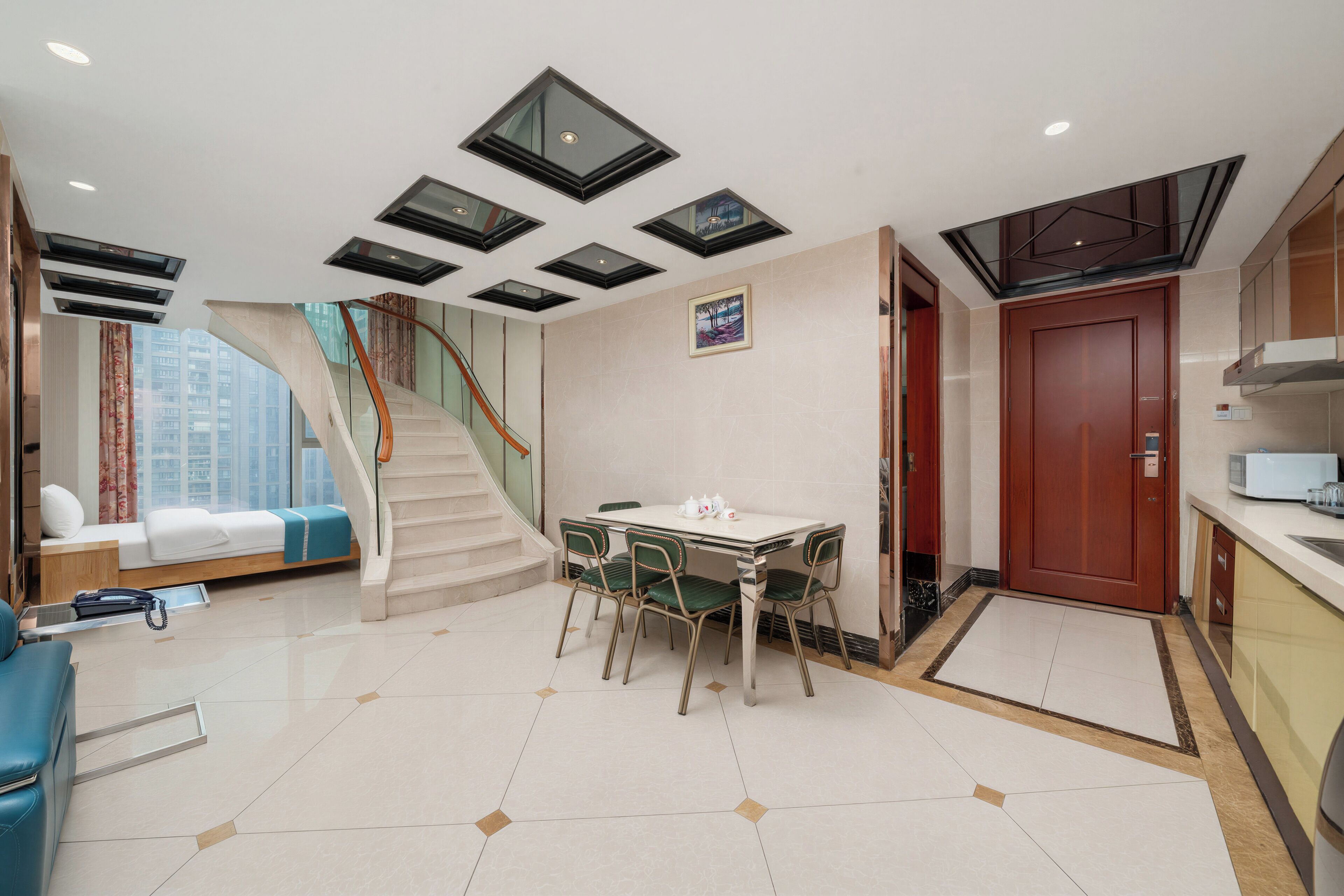 A modern hotel room with a dining area, a staircase, and a view of the city.
