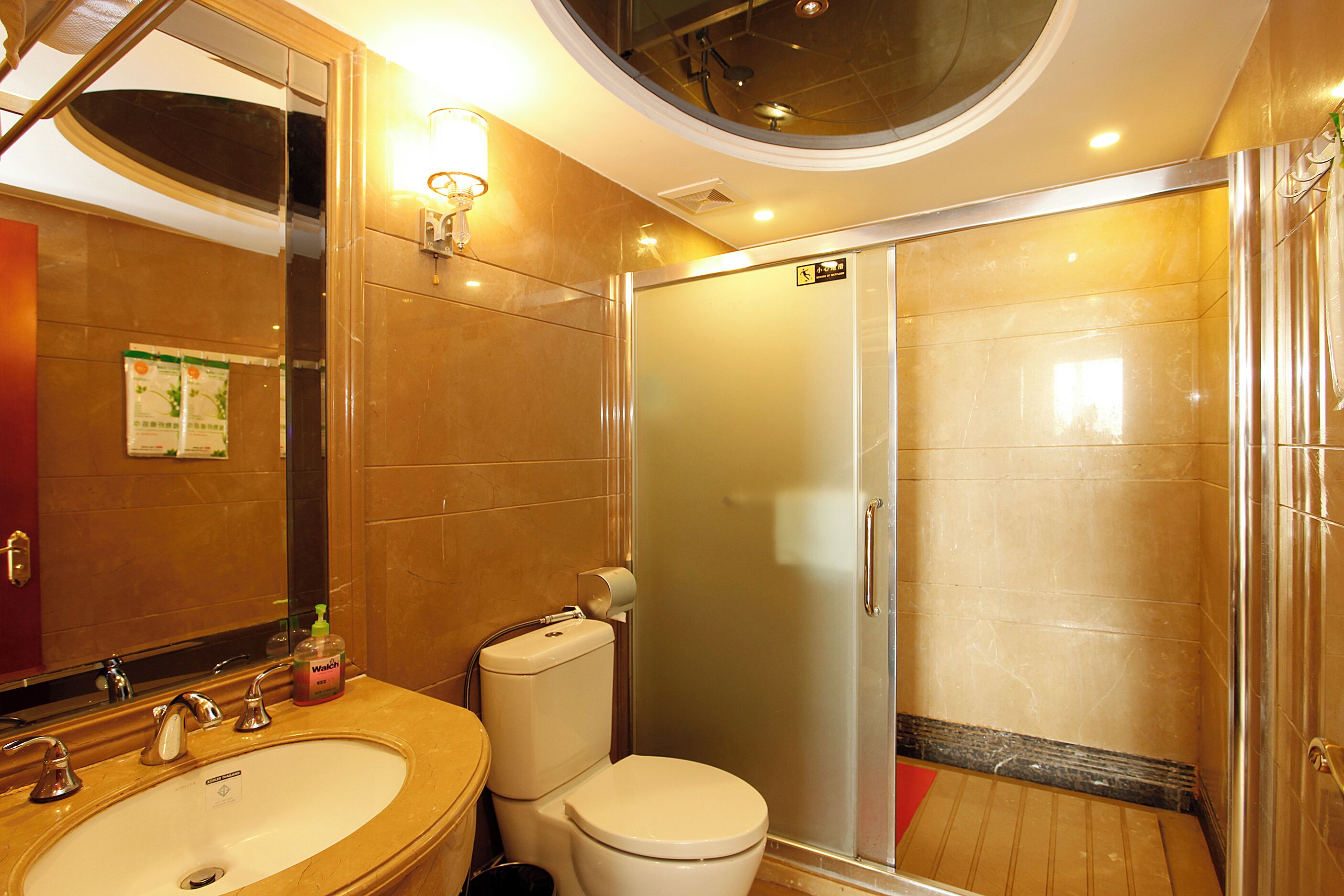 A bathroom with a sink, toilet, and a glass-enclosed shower.
