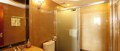 A bathroom with a sink, toilet, and a glass-enclosed shower.