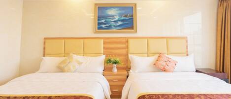 A hotel room with two beds, a nightstand with a vase of flowers, and a painting on the wall.