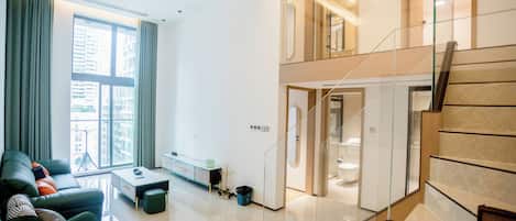 Egy modern apartman, amely nappalival, lépcsőházzal és kilátással rendelkezik a városra.