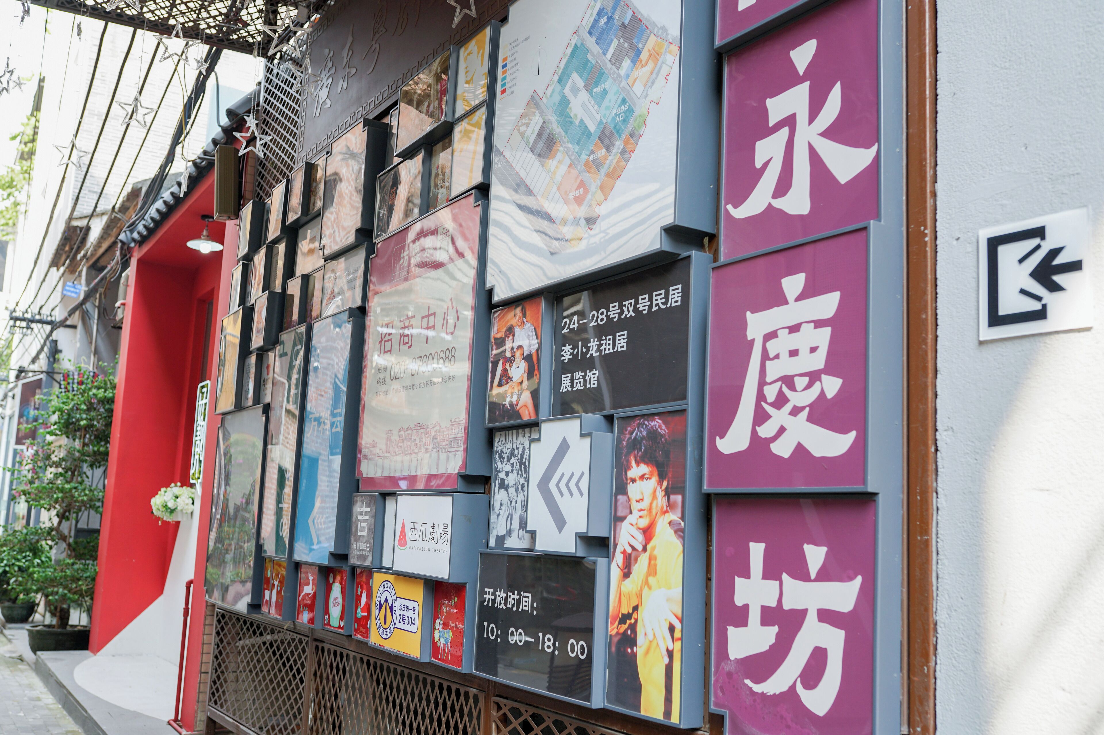 A row of posters on a building's facade, including a map and various advertisements.