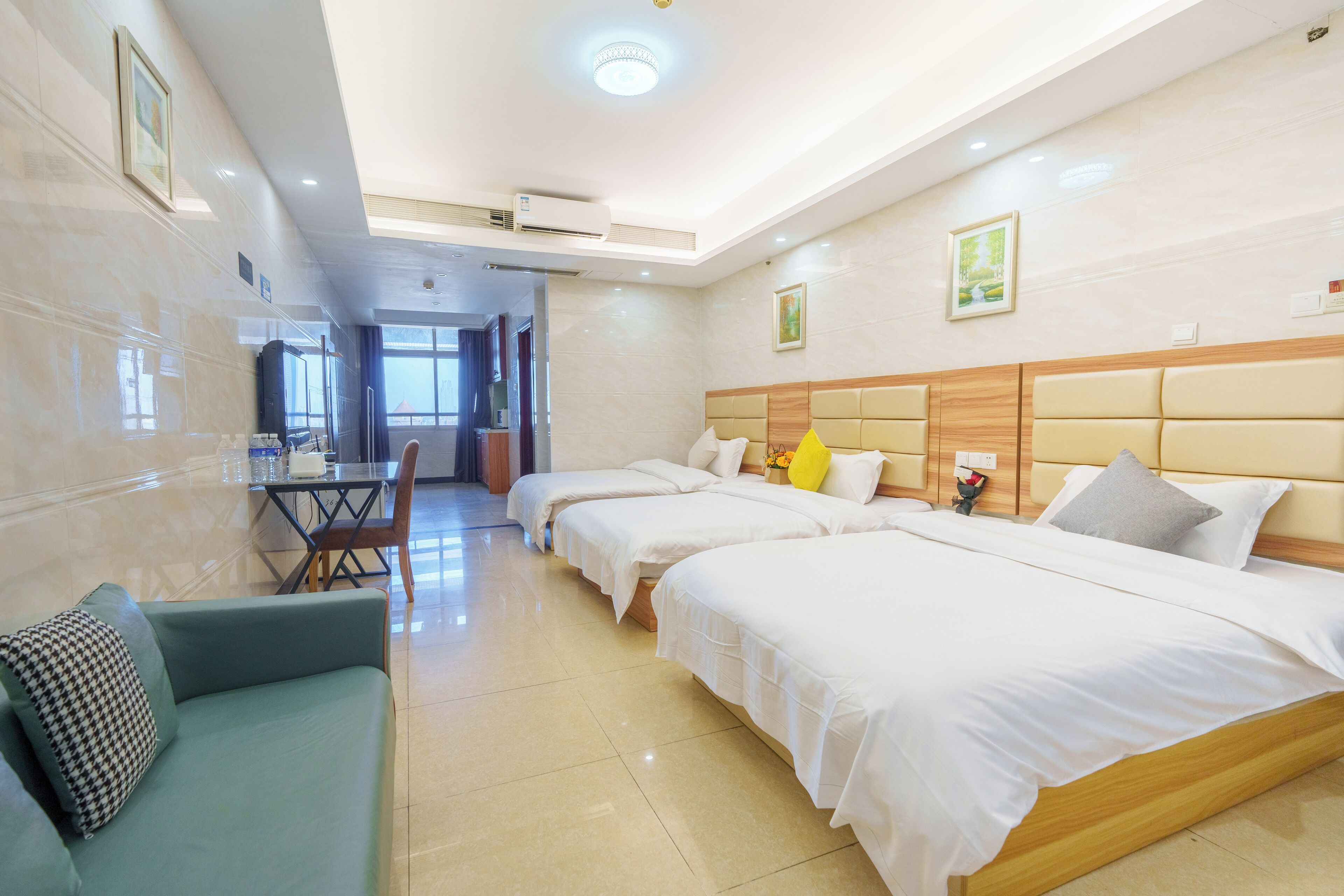 Une chambre d’hôtel avec trois lits, un canapé, une table à manger et des chaises.